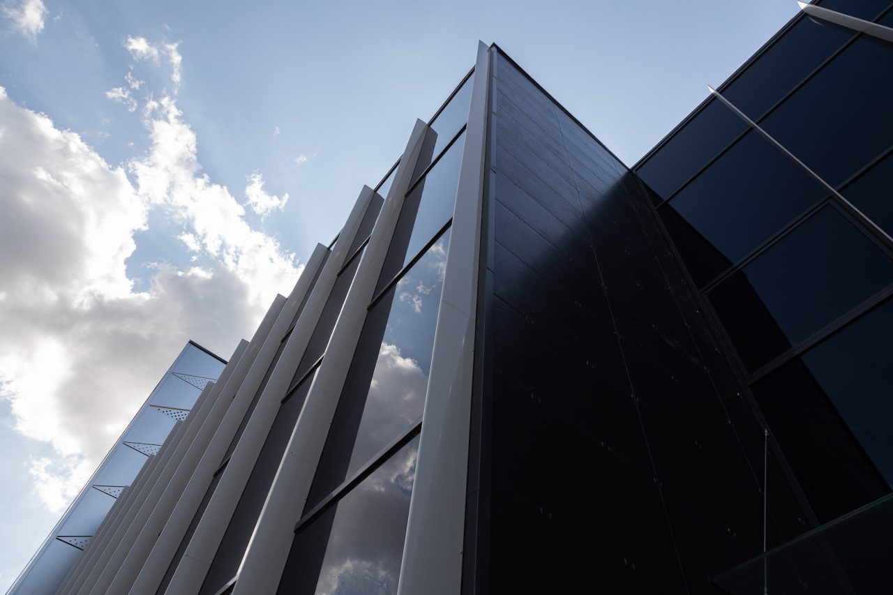 bottom view of new and modern building with glass walls reflecting sky.jpg